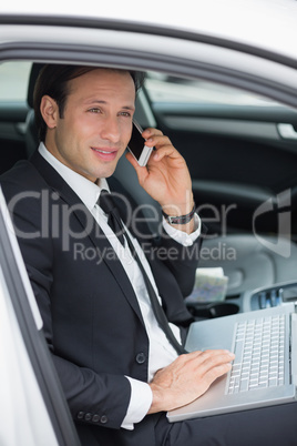 Businessman working in the drivers seat