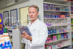 Senior pharmacist using tablet pc