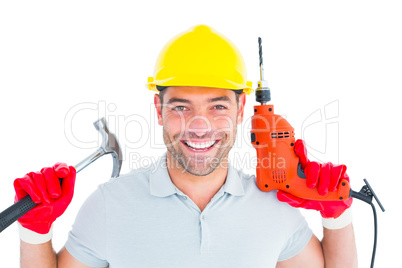 Happy repairman holding hammer and drill machine
