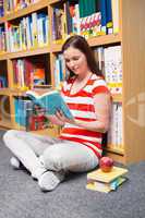Pretty student sitting on floor in library