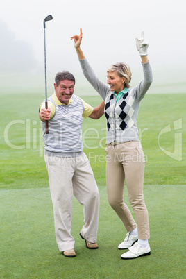 Excited golfing couple cheering Excited golfing couple cheering