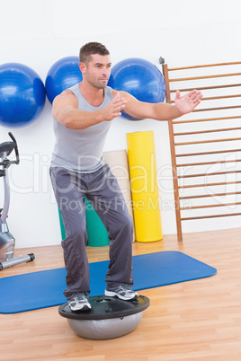 Concentrate man training in bosu ball