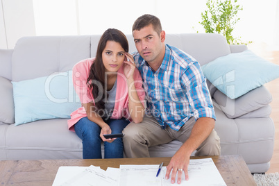 Portrait of worried couple calculating home finances