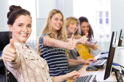 Students gesturing thumbs up in computer class