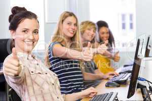 Students gesturing thumbs up in computer class