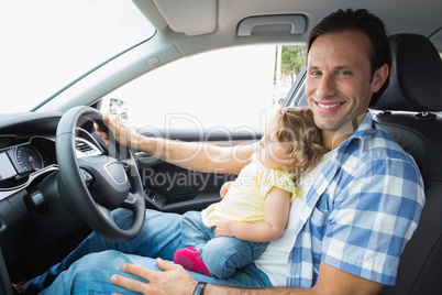 Father playing with baby in drivers seat