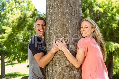 Happy couple hugging a tree