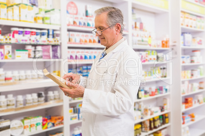 Smiling senior pharmacist reading prescription