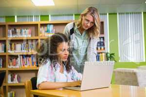 Student getting help from tutor in library