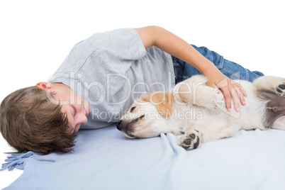 Boy lying with puppy on blanket