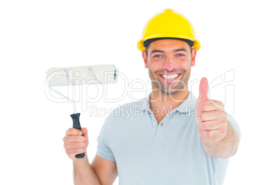 Manual worker with paint roller gesturing thumbs up