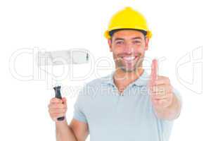 Manual worker with paint roller gesturing thumbs up