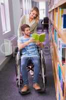 Smiling disabled student with classmate in library