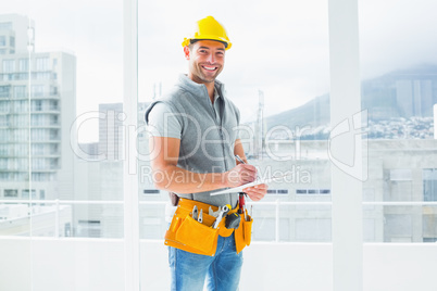 Manual worker writing on clipboard in building
