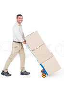 Happy delivery man pushing trolley of boxes