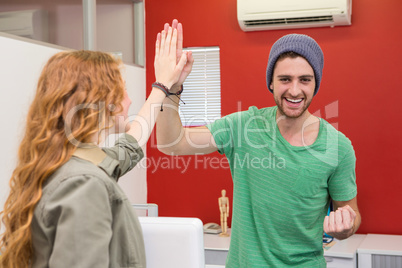 Casual businessman and woman high fiving