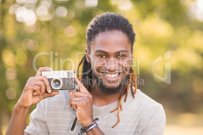 Handsome hipster using vintage camera