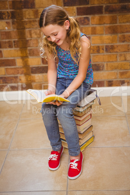 Cute little girl reading book in library