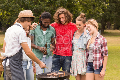 Happy friends in the park having barbecue