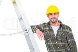 Smiling handyman in overalls leaning on ladder