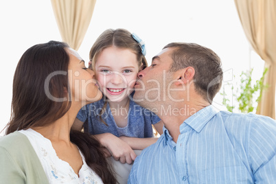 Happy girl being kissed by parents