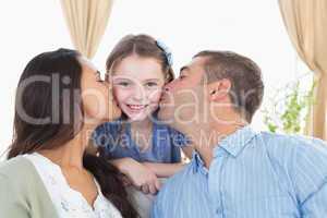 Happy girl being kissed by parents