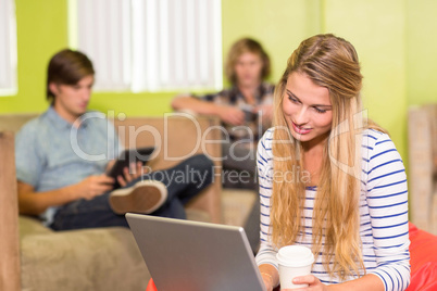 Casual young woman using laptop in office