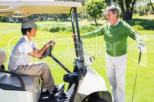 Happy golfing friends setting out for the day on buggy