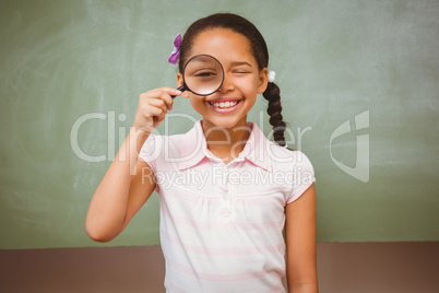 Portrait of cute little girl holding magnifying glass