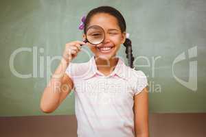 Portrait of cute little girl holding magnifying glass