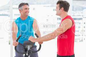 Trainer with man on exercise bike