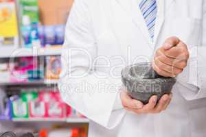 Pharmacist in lab coat mixing a medicine