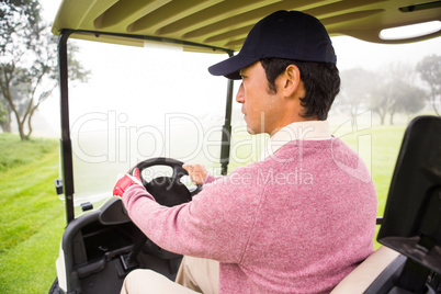 Golfer driving his golf buggy