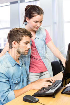 Computer teacher helping pretty female student