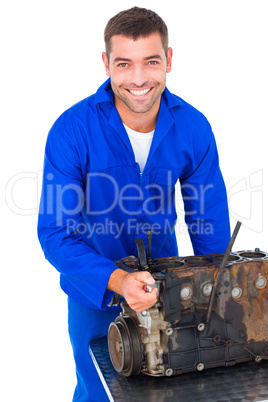 Smiling male machanic repairing car engine