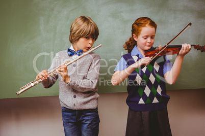 Students playing flute and violin in classroom
