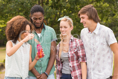 Happy friends in the park blowing bubbles