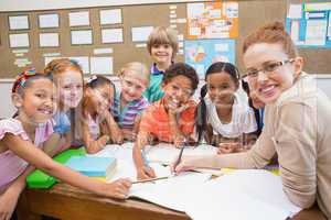 Teacher and pupils working at desk together