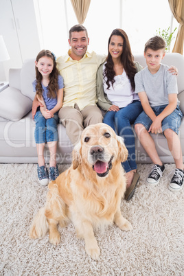 Portrait of smiling family with Golden Retriever