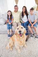 Portrait of smiling family with Golden Retriever