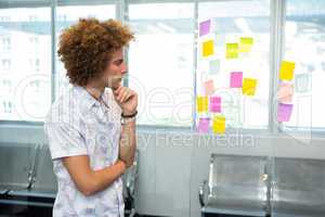 Creative businessman looking at adhesive note
