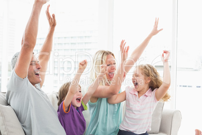 Family celebrating success while watching TV