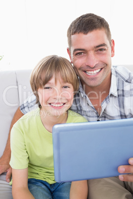 Happy father and son with digital tablet