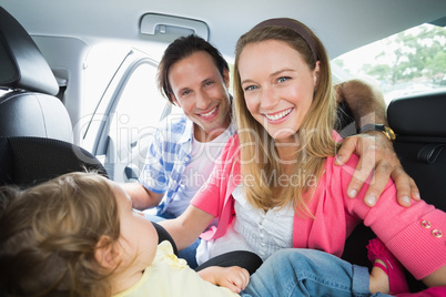 Parents securing baby in the car seat