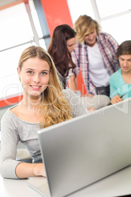 Female student using laptop in classroom