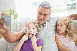 Father making face while taking selfie with children