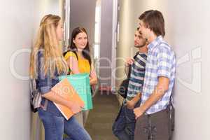 Students with files standing at college corridor