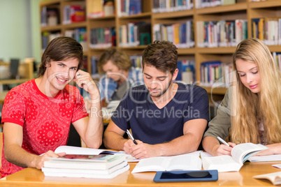 College students doing homework in library