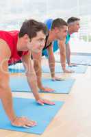 Group of men working on exercise mat