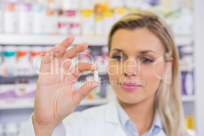 Smiling student in lab coat holding pill